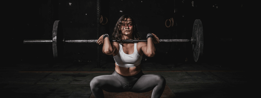 Woman performing a deadlift with Olympic bar and plate weights