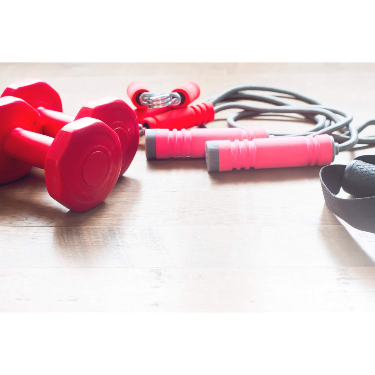 Red dumbbells, a skipping rope with red handles. And red forearm handgrips